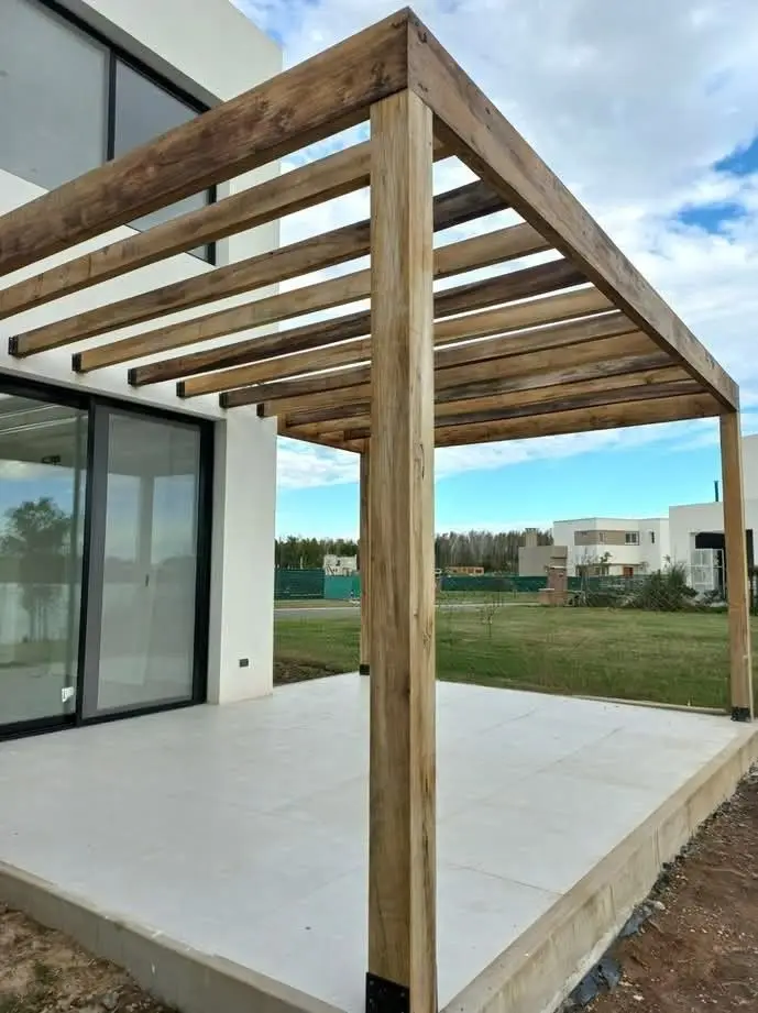 Pergola en bois massif, structure ouverte sans couverture, sur terrasse carrelée