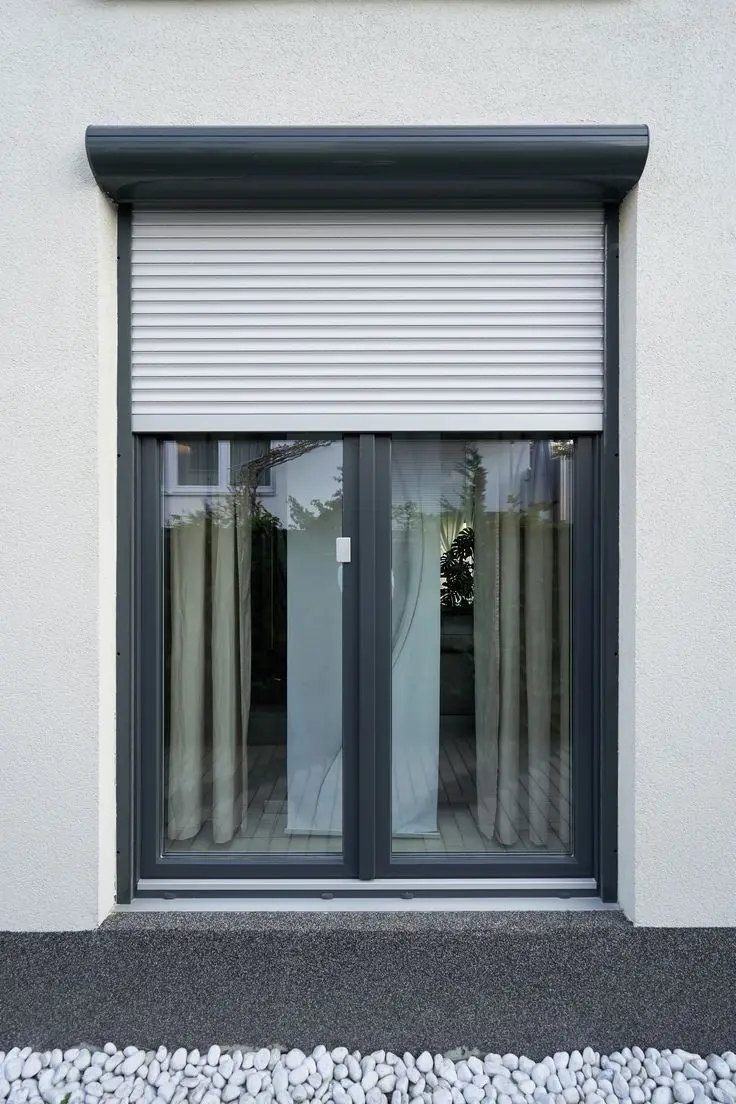 Volet roulant aluminium anthracite sur une façade blanche