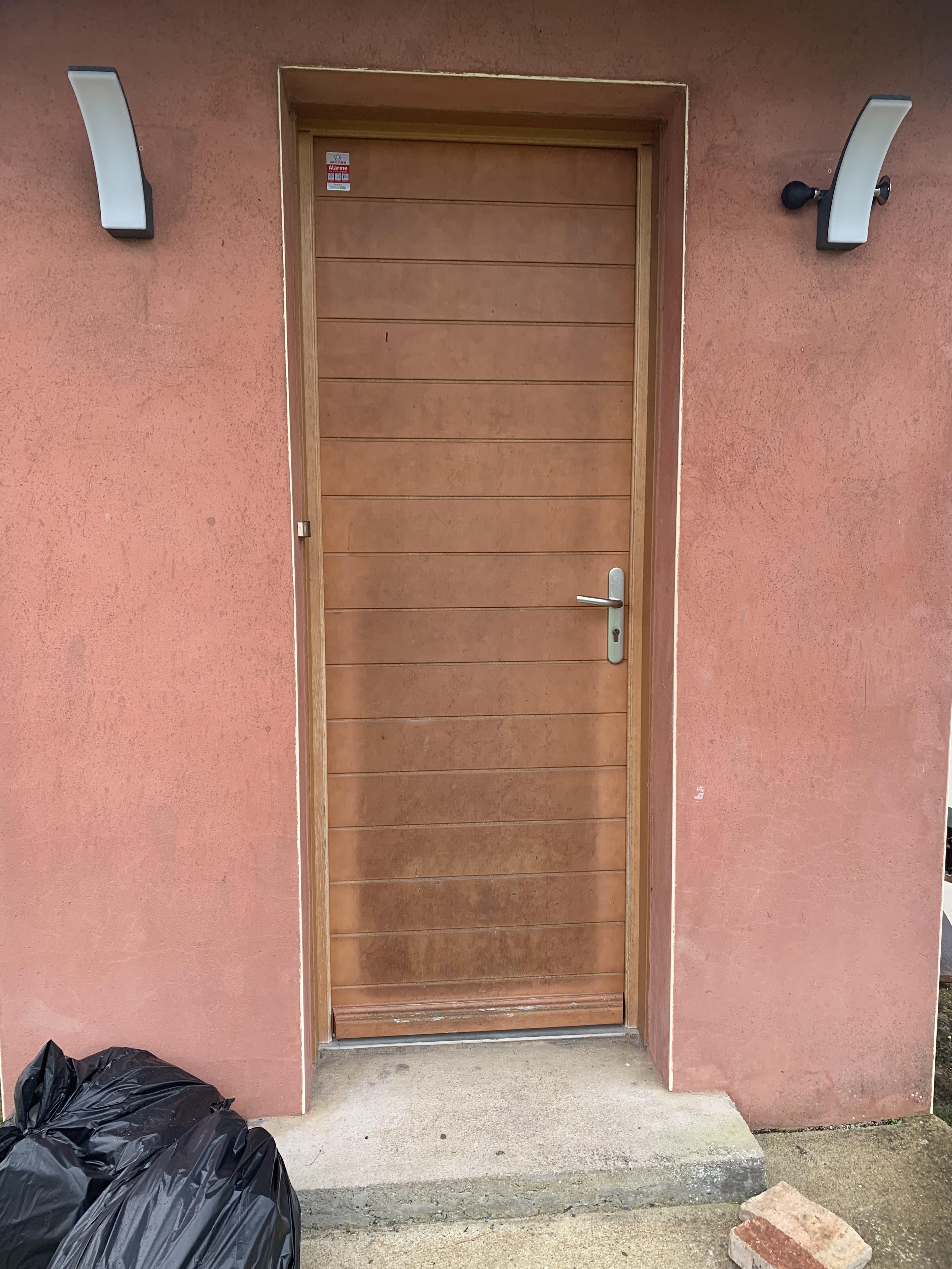 Avant : ancienne porte d'entrée bois vieillissante sur façade rose