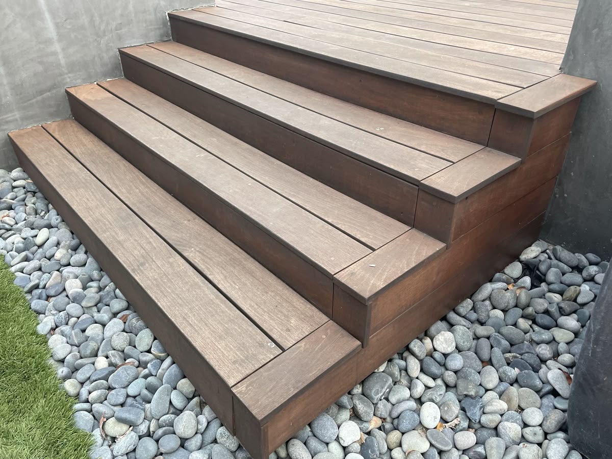 Escalier extérieur en bois composite terminé, entouré de galets décoratifs