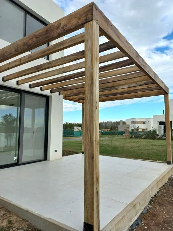 Pergola en bois massif, structure ouverte sans couverture, sur terrasse carrelée