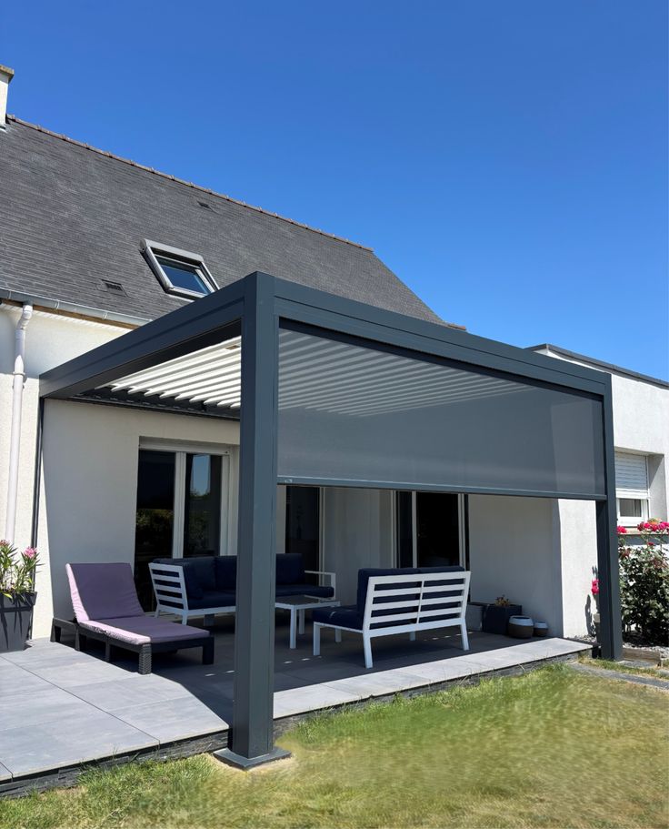 Pergola bioclimatique avec store latéral déployé et mobilier de terrasse