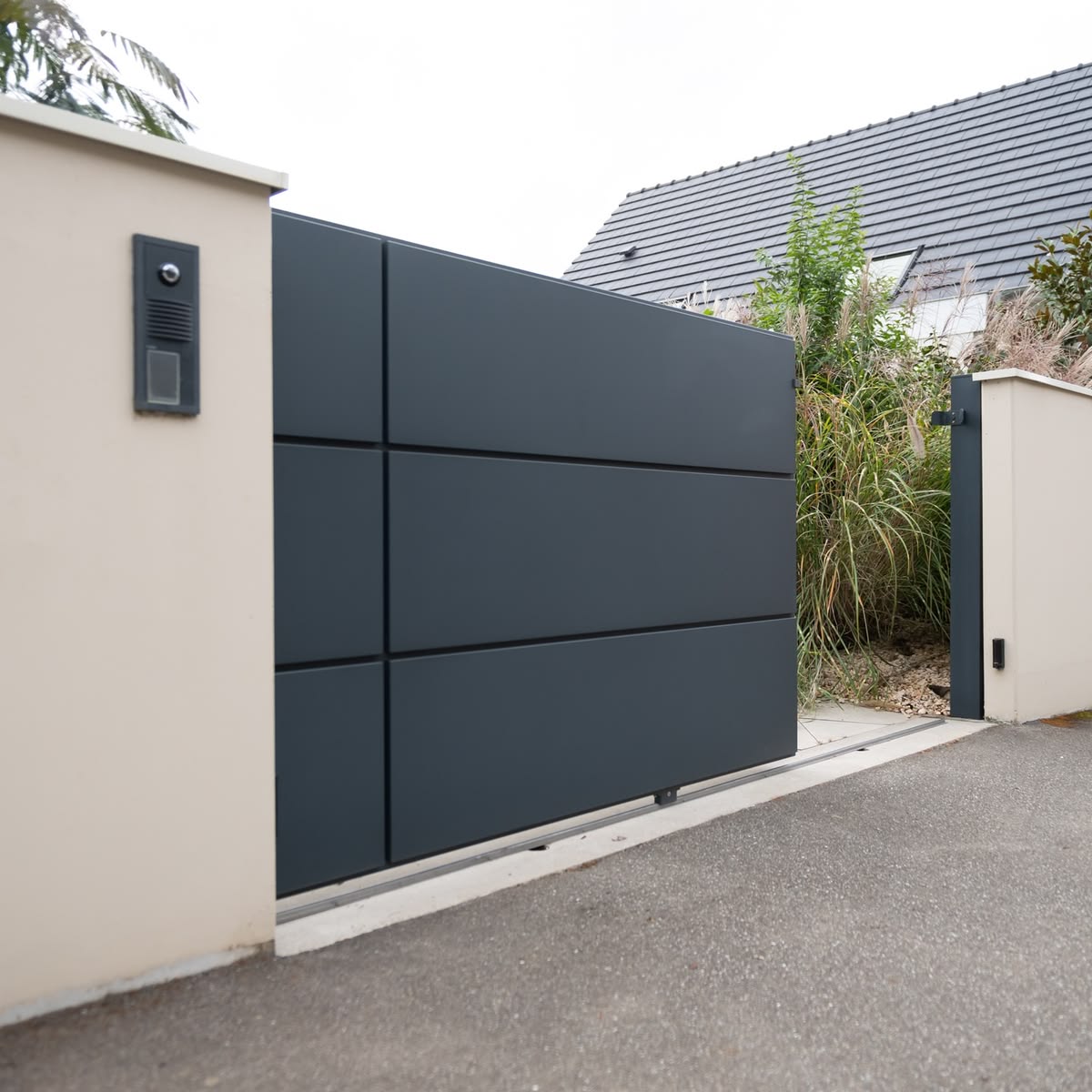 Portail coulissant aluminium anthracite ouvert, avec visiophone intégré au pilier