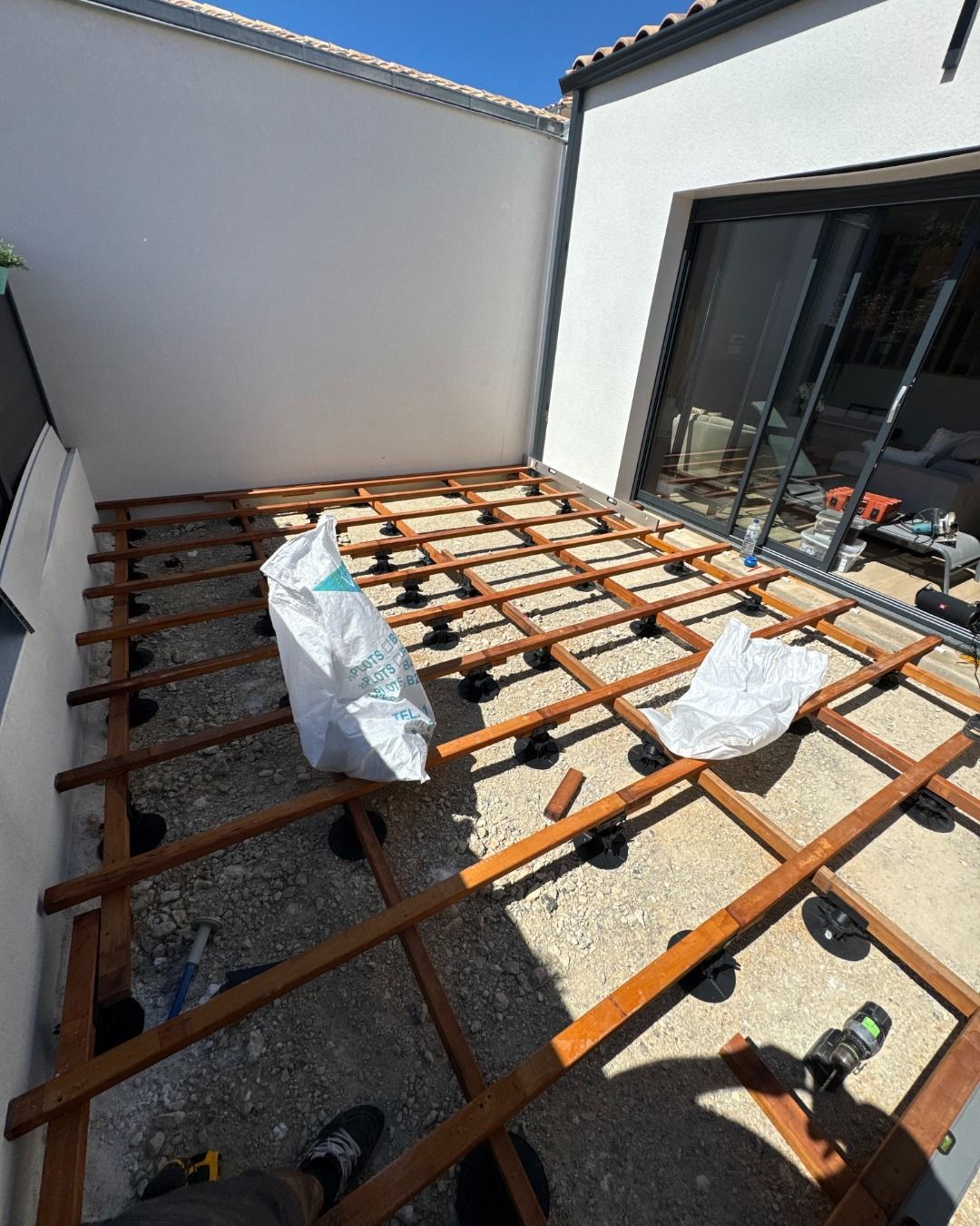 Avant : structure de lambourdes sur plots réglables avant pose des lames de terrasse
