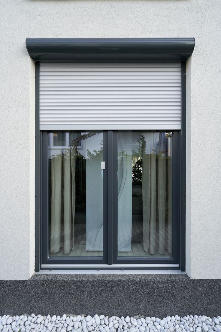 Volet roulant aluminium anthracite sur une façade blanche